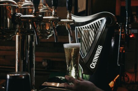 Pinta di Guinness appoggiata su un tavolo di legno in un pub